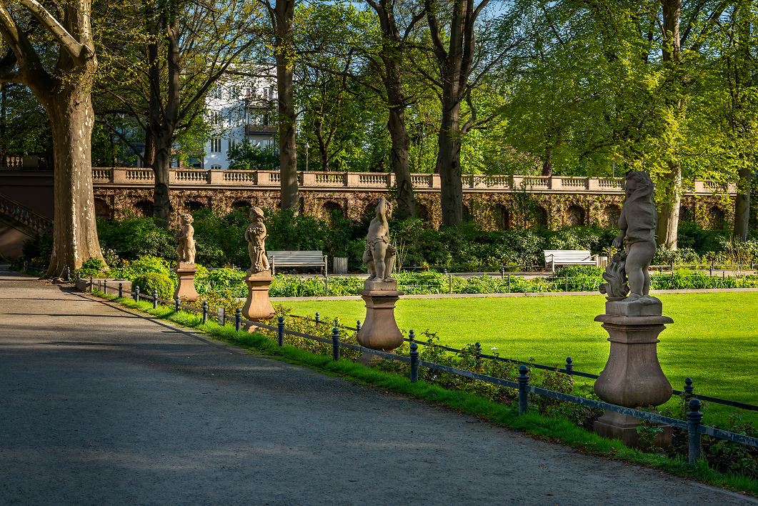 Skulpturen in einem sonnigen Park mit viel Grün.
