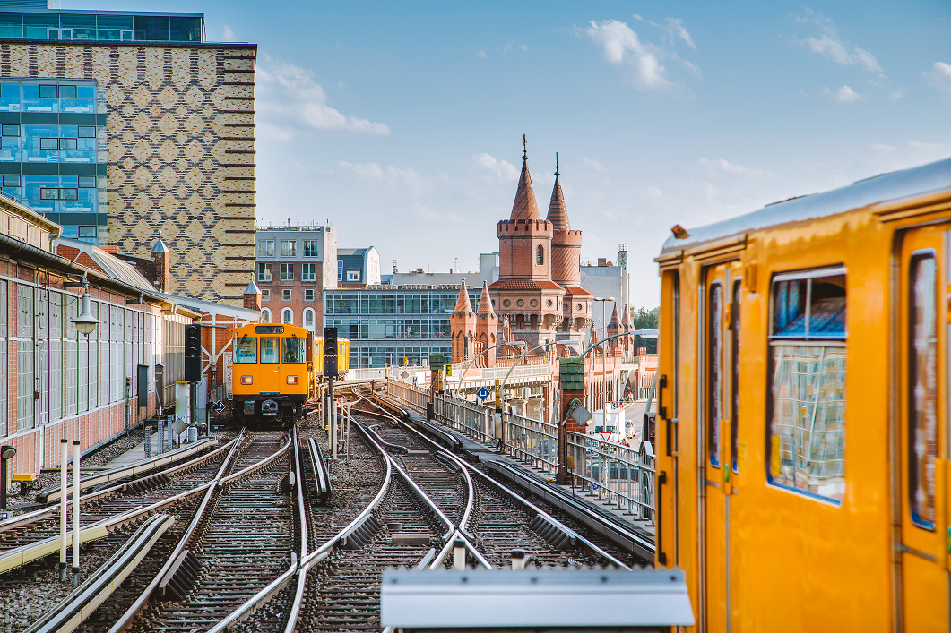 Gelber U-Bahn-Zug in Berlin, der durch die Stadt fährt.